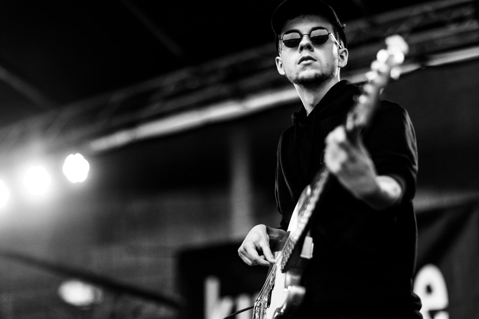 Lukas Hermanns spielt Gitarre auf einer Bühne
